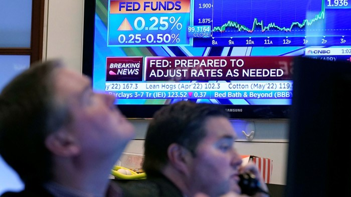 A television screen on the floor of the New York Stock Exchange, Wednesday, March 16 2022 shows the Federal Reserve’s decision to raise interest rates