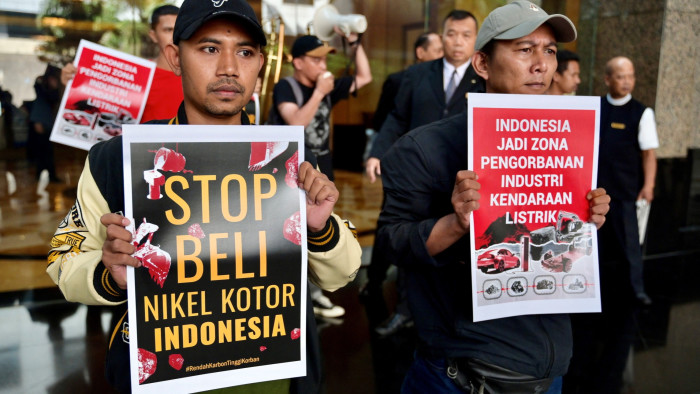Activists display posters saying ‘stop buying Indonesia’s dirty nickel and Indonesia has become a sacrifice zone for the electric vehicle industry’
