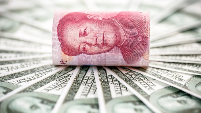 Hundred yuan note on a pile of US dollars