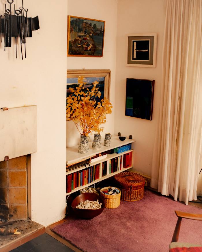 The marble fireplace design is by Trevor Dannatt, the painting of Hammersmith Bridge by Joan Dannatt, the abstract by John Levee, which is above Coucher de Soleil by Charlotte Jennings. The wooden bowl filled with shells and stones is by Finn Juhl