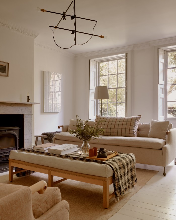 The ground floor living room. Above the fireplace is an artwork by Alfred Wallis; by the window is a piece by Rachel Whiteread. The sofa is from BDDW and the footstool from Howe antiques