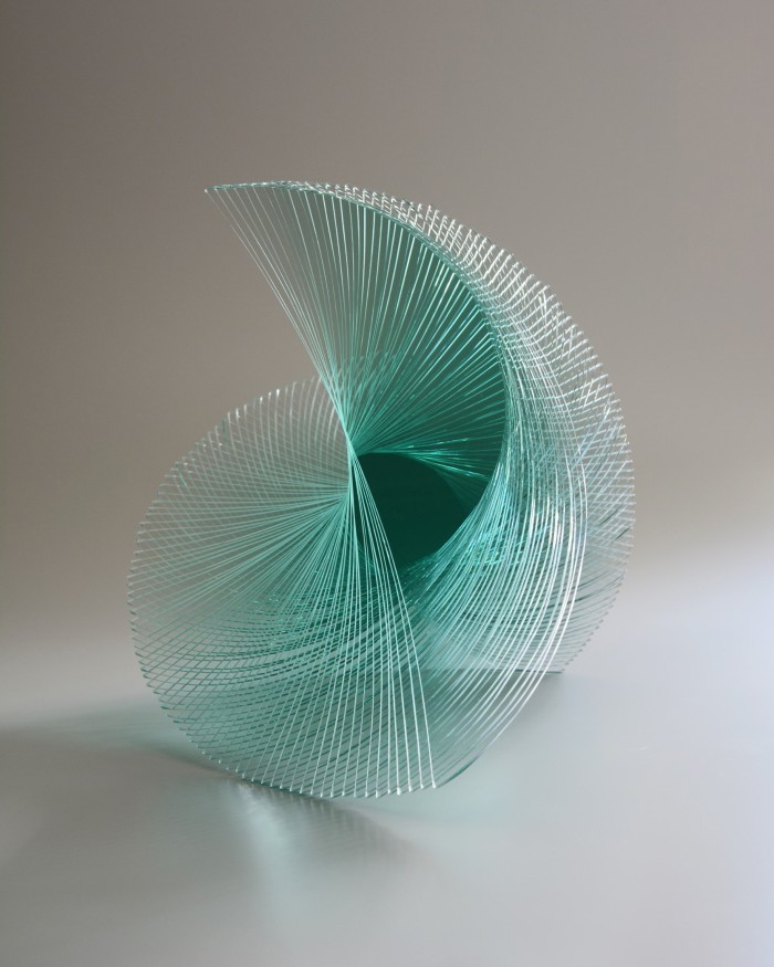 A glass sculpture which looks like a semicircle turning through space