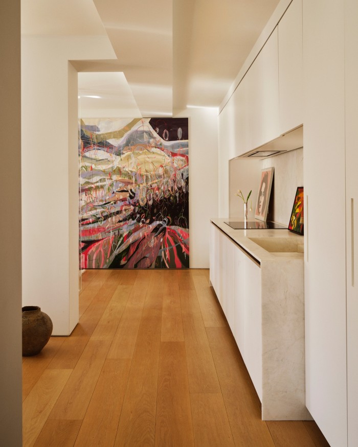 A painting by US artist Marley Freeman, an Andy Warhol portrait of Elizabeth Taylor and a silver Gio Ponti vase on a kitchen counter, looking towards an oil painting by German-Brazilian artist Janaina Tschäpe. On the floor stands an antique clay vase