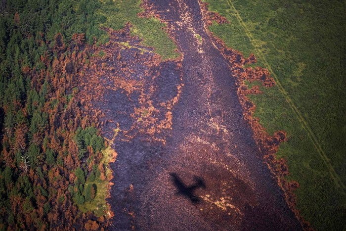 Shadow of an aircraft of the Air Forest Protection Service flying over a burned forest in the Russian Republic of Sakha