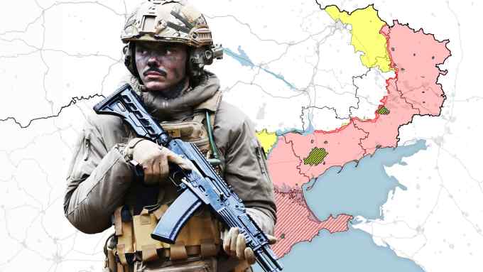 A soldier from the Bureviy assault brigade on exercise in woods near Kyiv, next to a map showing eastern Ukraine