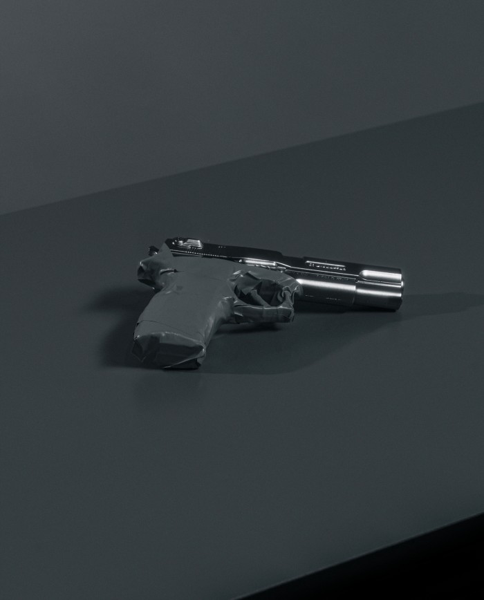 A pistol with masking tape covering the grip and trigger