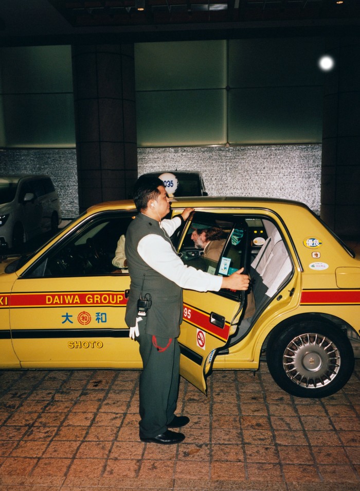 The author in a traditional yellow Tokyo taxi