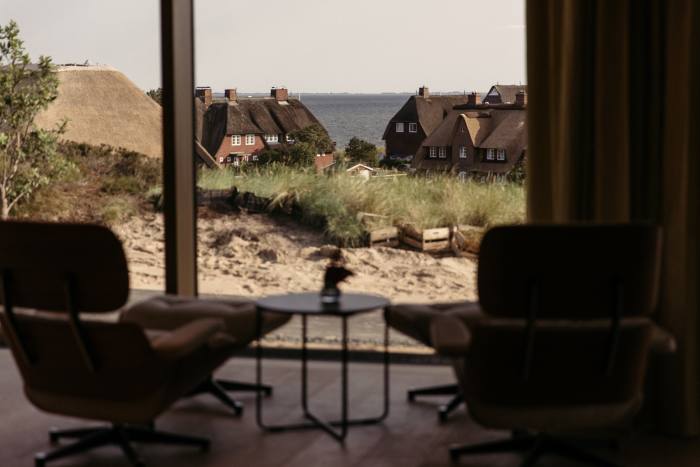 A relaxation area near the resort’s library, with custom-upholstered Eames lounge chairs, overlooks List and the Wadden sea