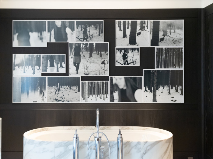 photographic artwork hangs above a marble bathtub