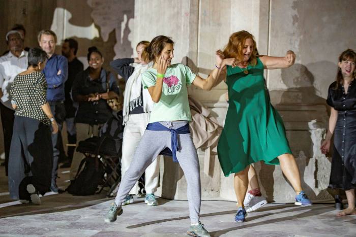 Two women are mid-energetic dance move