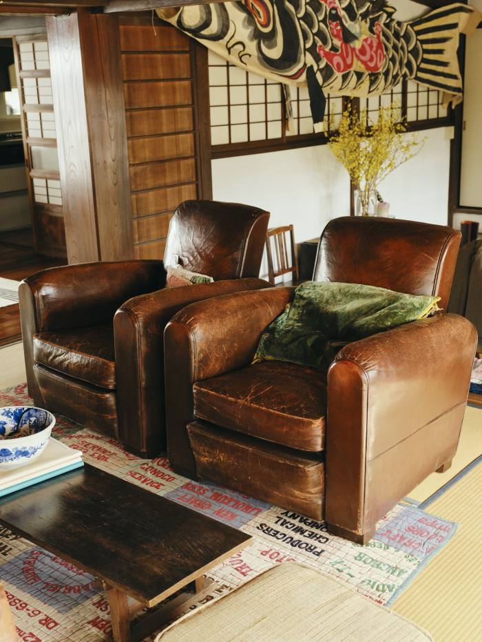 Two brown leather club chairs that he found in France
