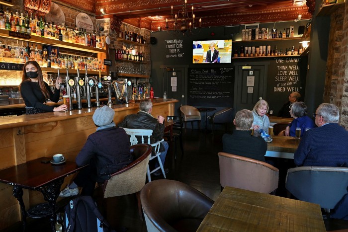 Pub-goers in Edinburgh watch Nicola Sturgeon’s announcement on TV on October 7