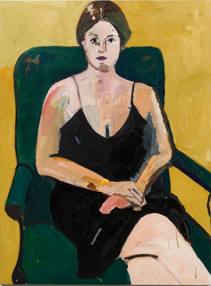 Portrait of a woman in a black dress sitting in a green chair in a yellow room