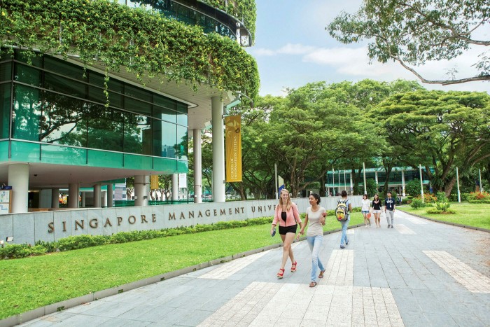 Students walking along the concrete pavement in front of the Singapore Management University