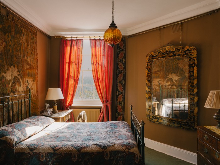 Renzullo’s bedroom, with 17th-century Flemish tapestry on the wall, 19th-century painted Iron bed from Miles Griffiths Antiques in Yorkshire and Austrian 19th-century découpage side table