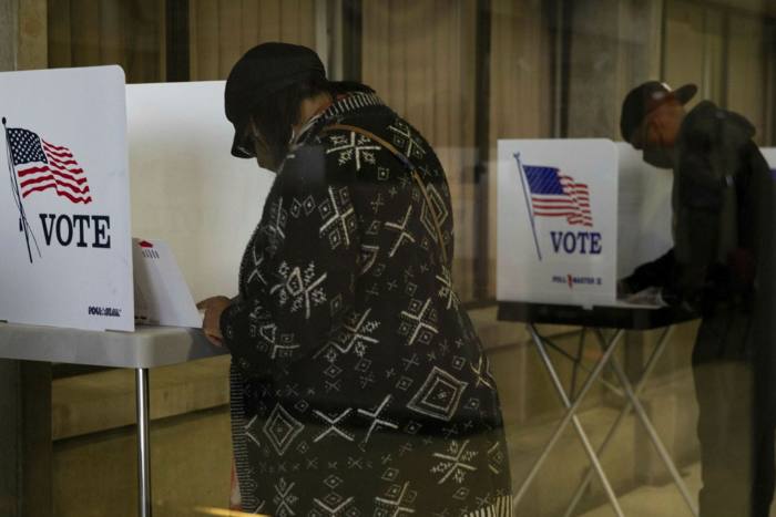 Voters wearing protective masks cast ballots at a polling location for the 2020 Presidential election in Southfield, Michigan