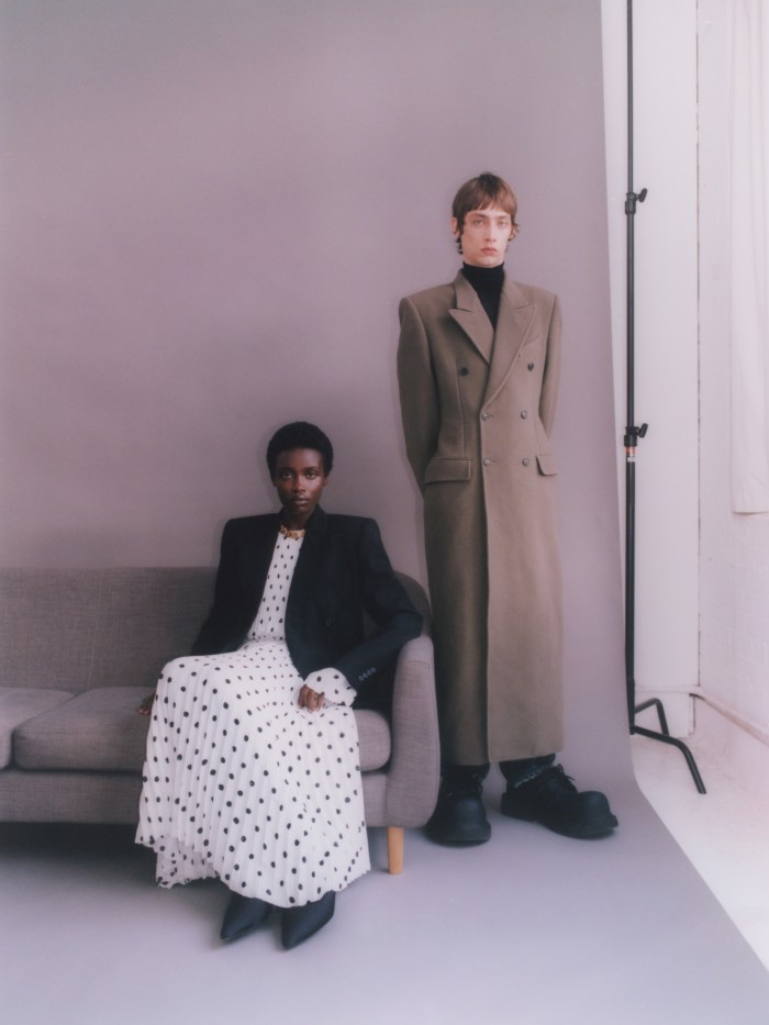 From left: Akidor wears stretch-wool jacket, £2,250, crepe pleated dress, £4,450. Spandex XL 110mm pumps, £1,050, gold brass Hourglass choker, £2,100. Bunny wears cashmere-mix coat, £3,450, cashmere turtleneck, £1,190, selvedge denim jeans, £875. Eva Steroid Derby shoes, £775. All Balenciaga Garde-Robe