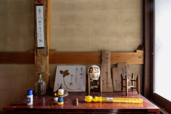 Some objects, including pieces of wood with characters inscribed on them, sit on a table