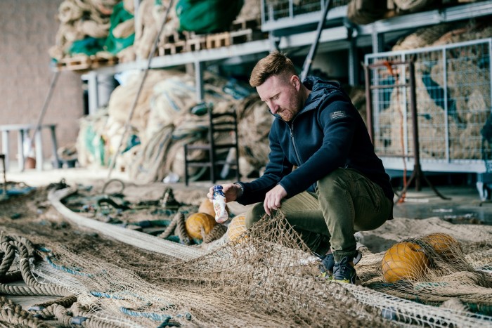 Fisherman Alessio Curella clears plastic waste from his net