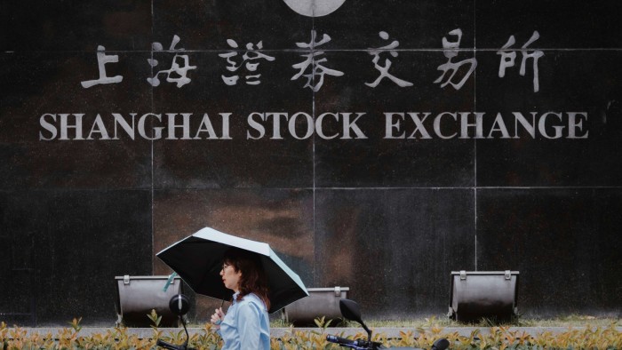 A woman walks past the Shanghai Stock Exchange building