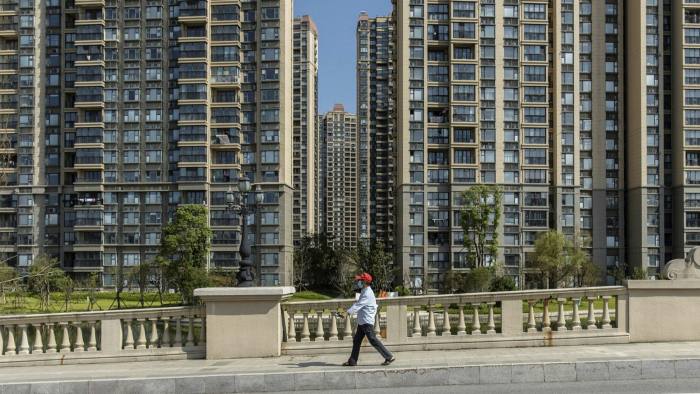 A resident walks past Evergrande apartment buildings in China