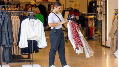 A woman chosing clothes in a Zara store