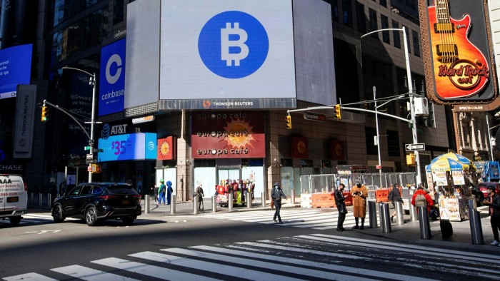 Monitors display Coinbase and bitcoin signage during Coinbase’s initial public offering on Nasdaq in April 2021 