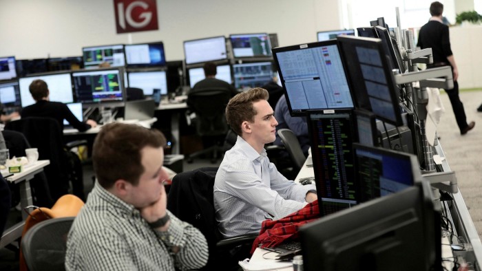 Financial market traders in front of screens 