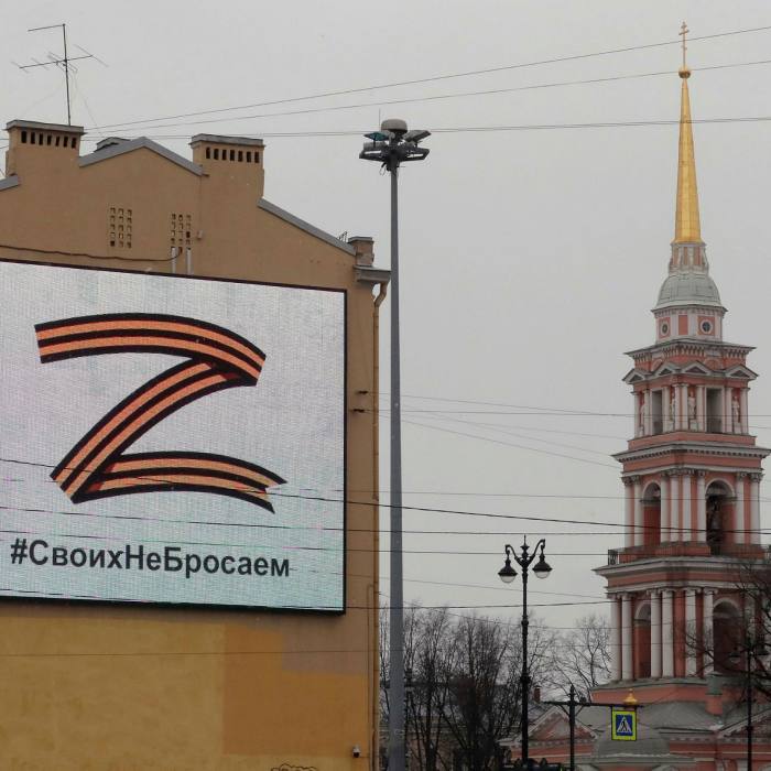 A large letter Z on a billboard, along with a hashtagged slogan in Russian