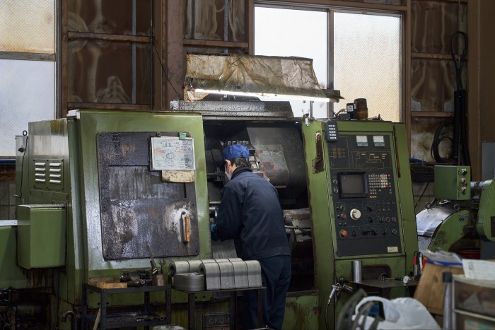 Araie employee using a machine in its factory