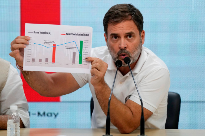 Congress party leader Rahul Gandhi shows a stock market movement chart during a press conference in New Delhi