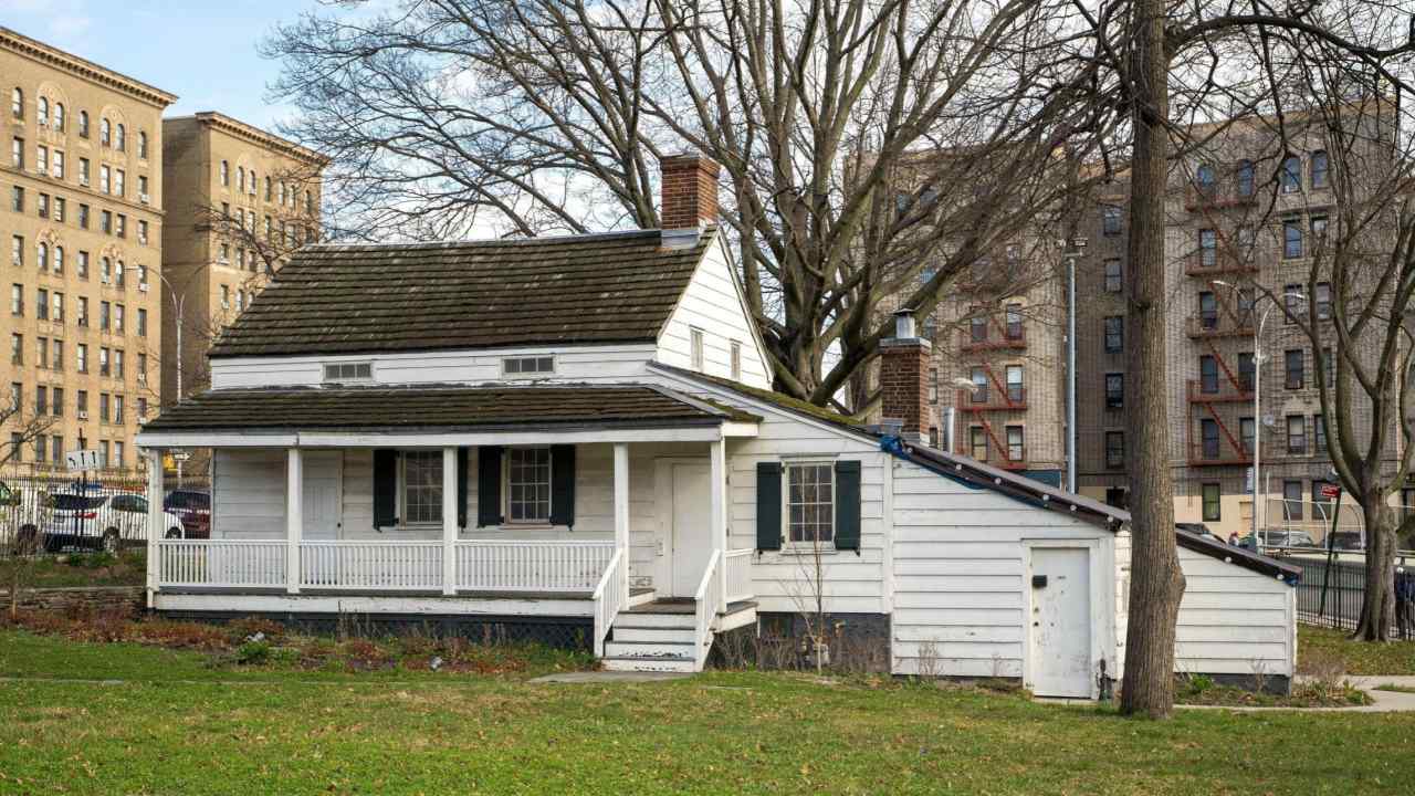 Poe’s home in the Bronx, a small white clapboard cottage surrounded by tall modern buildings