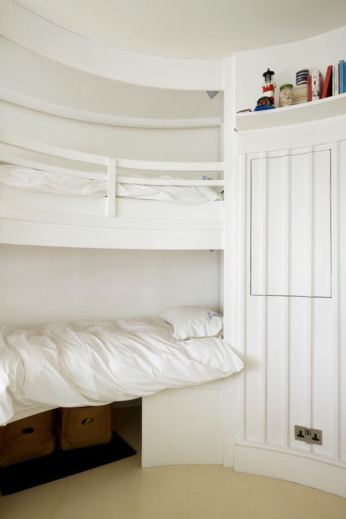 A white-painted bedroom in Winterton Lighthouse, with two built-in bunk beds