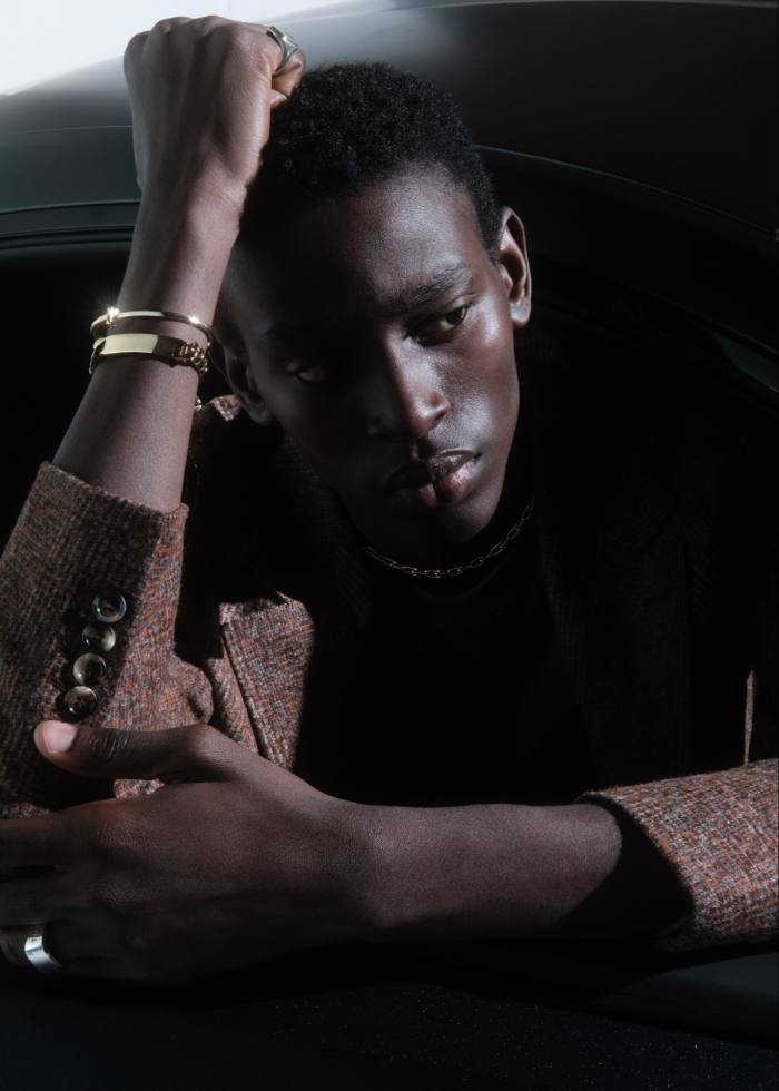 Adamu wears Brunello Cucinelli wool jacket, £3,450. Tiffany & Co gold and silver Square signet ring (on right hand), £1,250, gold T1 narrow-hinged bangle, £3,600, gold ID Curb bracelet, £8,600, silver Makers ring (on left hand), £620, and gold HardWear graduated-link necklace, £12,900
