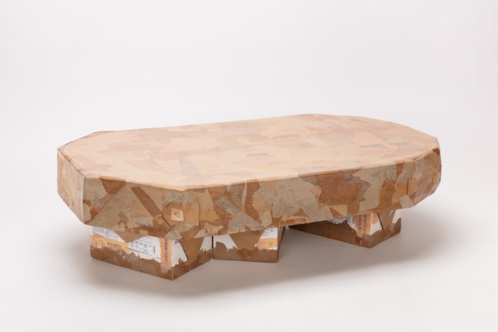 A brown low long rounded-edge table made from cardboard