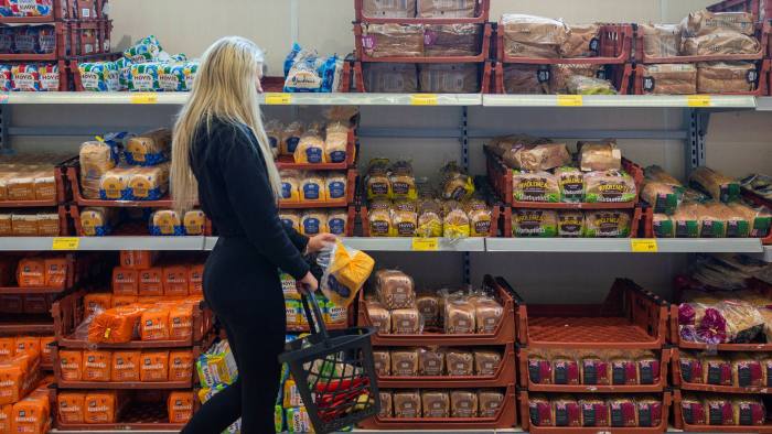 A woman shops for bread in a supermarket