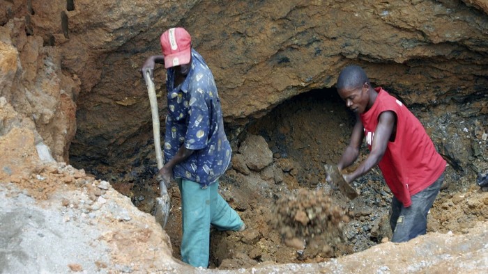 Artisenal miners dig in an open-pit mine outside the southern Democratic Republic of Congo copper town of Lubumbashi