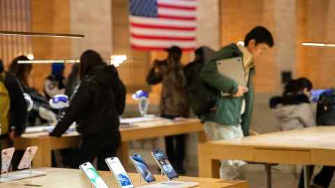 Customers shop at an Apple electronics store