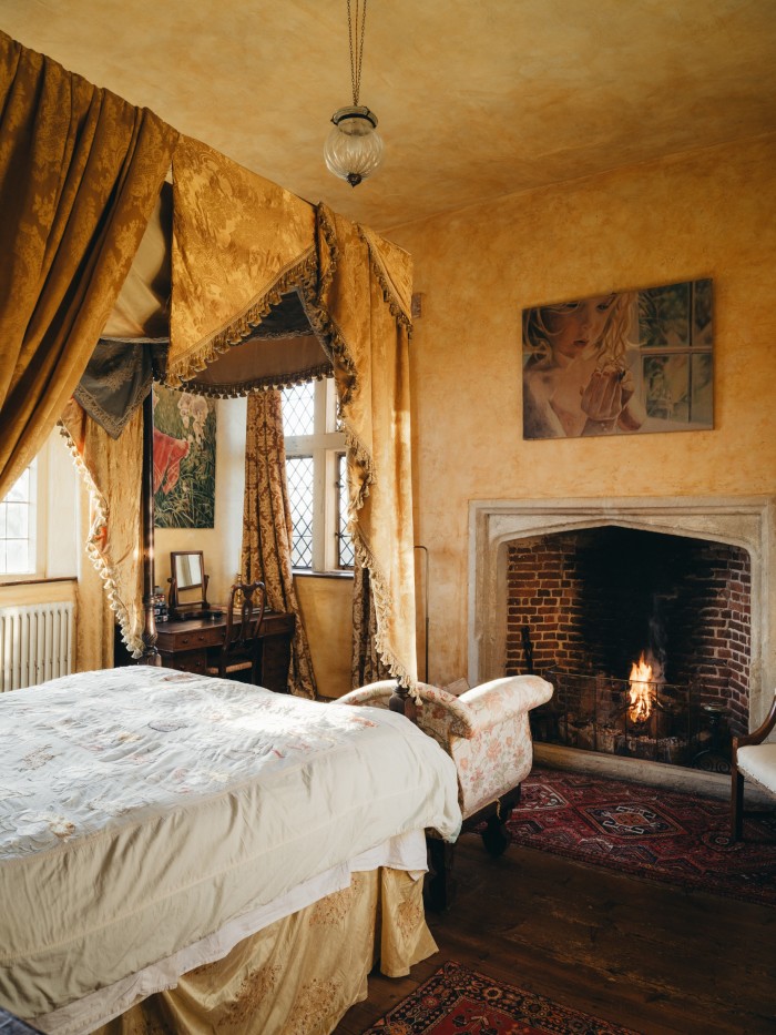 A bedroom, with one of Feilding’s paintings, Rocky with Butterfly, over the fireplace