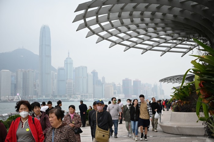 Tourists from mainland China walk along the harbour front in Hong Kong