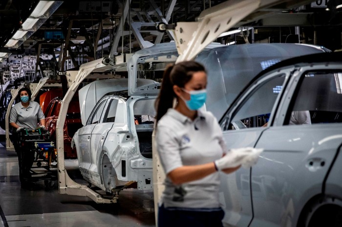 Employees work on the production line at a Volkswagen factory near Lisbon, Portugal. A recent VW advert showed one of its cars covered in a face mask, with the slogan 'Safety first' written underneath