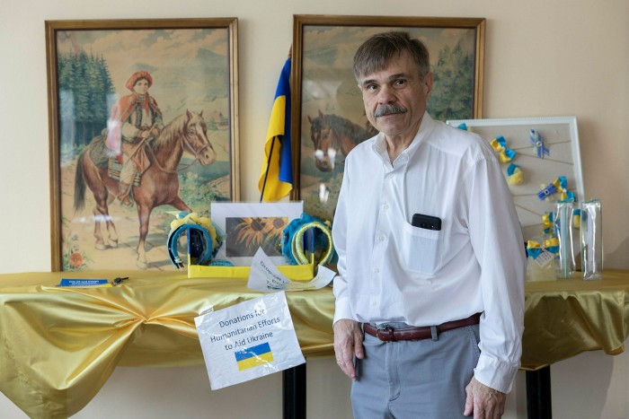 Eugene Luciw in front of Ukrainian flags