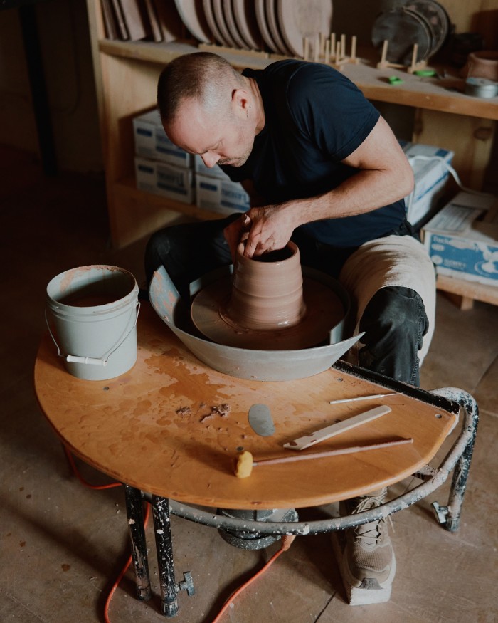 Anderson works on a piece at the wheel in his atelier