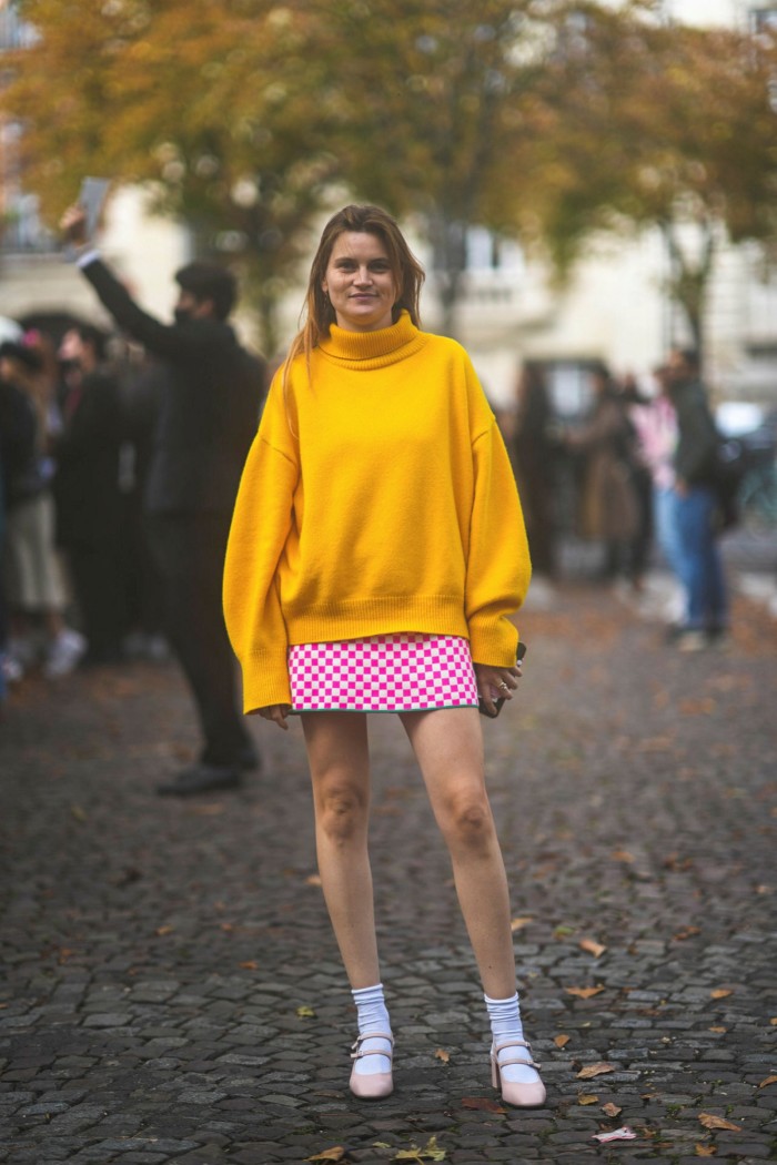 Eugénie Trochu in yellow pullover, short skirt, socks and block heel outside Miu Miu during Paris Fashion Week 