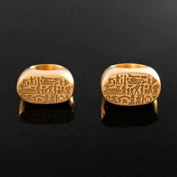 Two gold rings with large flat surfaces showing hieroglyphic-like people