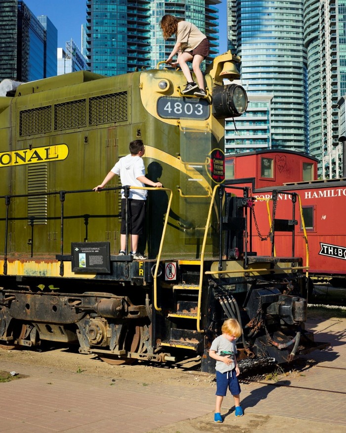 Children playing on old trains in a railway museum next to Steam Whistle
