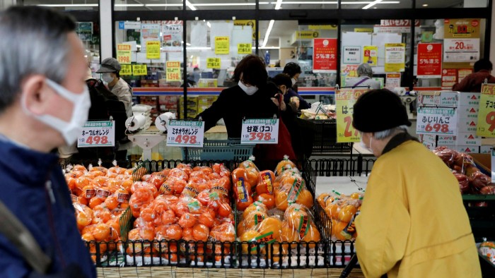  Shoppers in protective face masks at a supermarket in Tokyo