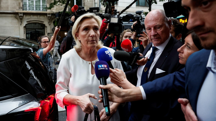 Marine Le Pen speaking to media as she arrives at the RN party headquarters
