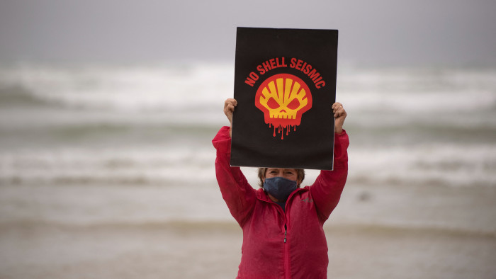 A woman holds a placard on the beach at a protest against Shell’s plan to conduct underwater seismic surveys along South Africa’s east coast