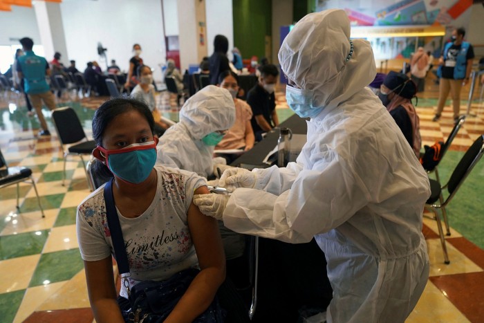 A health worker administers the Sinovac shot at a vaccination center set up at a shopping mall  in Tangerang, Indonesia